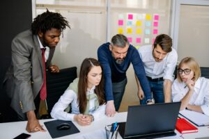 A diverse group of colleagues working together on a project in a modern office space.